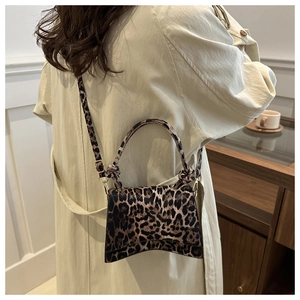 Détail du sac léopard avec base incurvée unique et poignée nouée pour un style chic