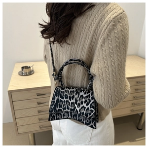 Détail du sac à main léopard montrant la base incurvée et la texture synthétique de qualité