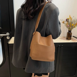 Chic brown lychee pattern leather bucket bag for women, crossbody style shown on model