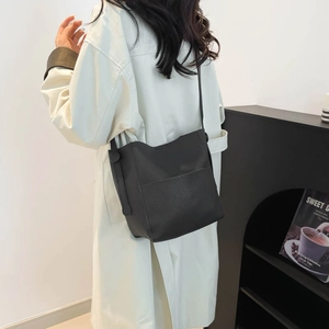 Minimalist black lychee pattern leather bucket bag with front pocket for stylish women