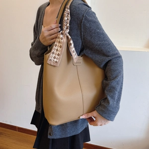 Brown leather tote bag with plaid scarf and fashion label for women's daily commute