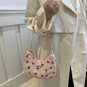 Pink corduroy crescent hobo bag with strawberry print and metallic detail