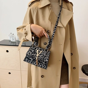 Borsa a tracolla leopardata vintage con fibbia a V dorata su modella elegante
