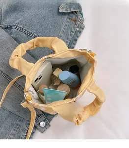Interior view of yellow canvas bucket bag showing large capacity for cosmetics and phone