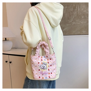 Detail of pink bucket bag featuring cartoon rabbit print and adjustable shoulder strap