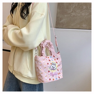 Detailed shot of pink striped canvas bucket bag featuring cute rabbit and strawberry print