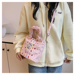 Close-up of pink bucket bag with cartoon rabbit print and ruffled top handle detail