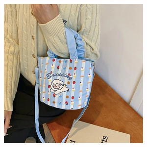 Detail of blue striped canvas bucket bag with cute sheep pattern and ruffled handle