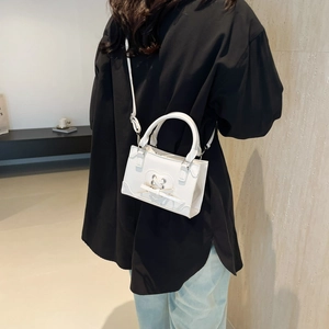 Chic white mini square shoulder bag with heart cutout and bow detail on a model