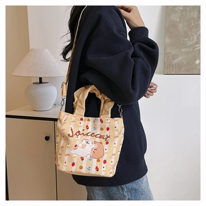 Detail of canvas bucket bag with cute cat illustration and pleated handle texture
