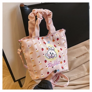 Detail of pink canvas bucket bag featuring cute rabbit print and ruffled handle design