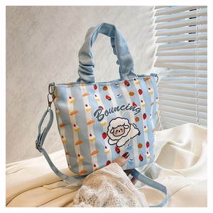 Detail of light blue striped bucket bag with sheep cartoon and adjustable strap