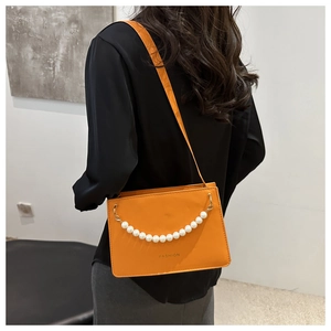 Detail of bright orange square crossbody bag with pearl chain and fashion logo