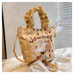 Detail of yellow striped canvas bucket bag featuring a cartoon cat and ruffled handle