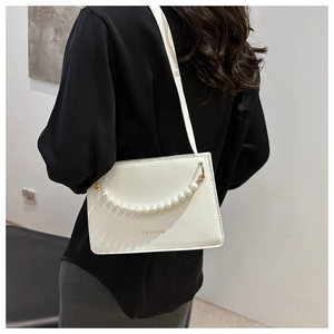 Detail of white square crossbody bag with pearl chain and fashion lettering