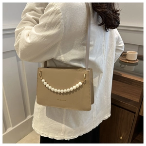 Detail of beige leather crossbody bag featuring pearl chain and fashion letter print