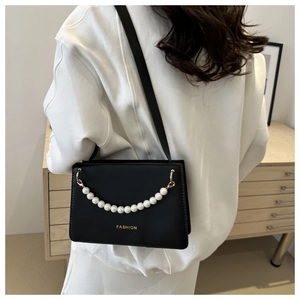 Detail view of black leather shoulder bag featuring a pearl chain and Fashion logo