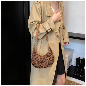 Détail du sac hobo à imprimé léopard avec bandoulière en cuir marron sur l'épaule