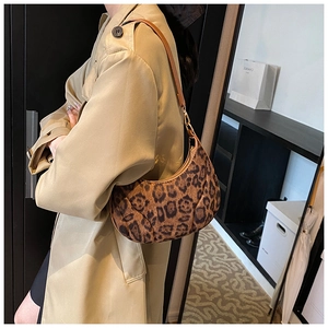 Détail du sac croissant à motif léopard avec bandoulière en cuir brun et métal doré