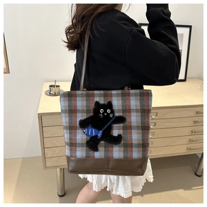 Détail du sac cabas à carreaux avec écusson chat en 3D et fond en cuir marron durable