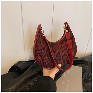 Détail du sac hobo avec imprimé léopard rouge foncé, velours et boucle dorée