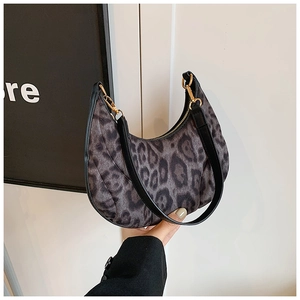 Détail du sac croissant léopard avec texture en fausse fourrure et boucles dorées