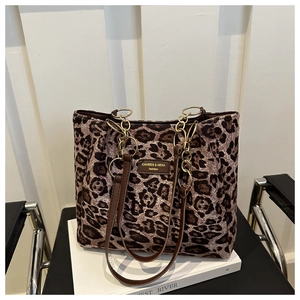 Detailed view of leopard print tote bag with leather straps and gold metal chain links