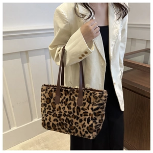 Close-up of leopard print faux fur tote bag with brown leather straps on a model