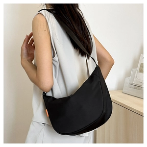 Detailed view of black nylon hobo bag showing adjustable wide strap and orange accent label
