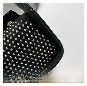 Detailed macro view of black leather handbag with silver round rivet decorations