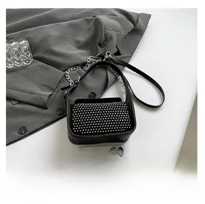 Detail of black leather underarm bag with silver rivets and detachable metal chain