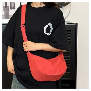 Detail of red crescent shoulder bag with wide adjustable strap and black hardware