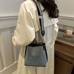 Sac seau mode avec strass argentés et bandoulière chevron sur trench-coat beige