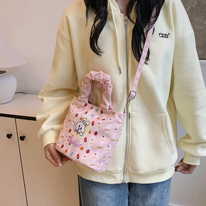 Pink canvas bucket bag with rabbit print and pleated handle in a soft lifestyle setting