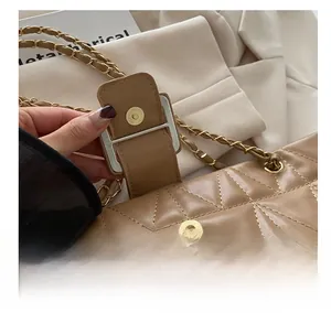 Dettaglio borsa trapuntata in pelle beige con fibbia magnetica e tracolla a catena