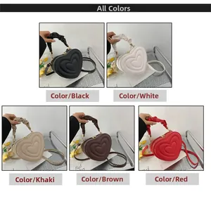 Macro detail of heart-shaped quilted handbags in black, white, khaki, brown, and red