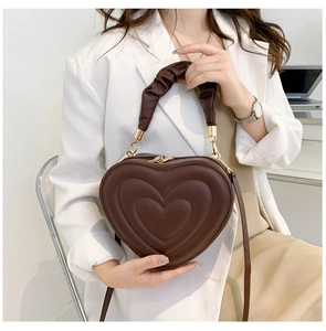 Detail of dark chocolate heart-shaped bag with embossed texture and pleated handle