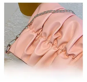 Detail of pink pleated leather shoulder bag with silver chain and rhinestone accents