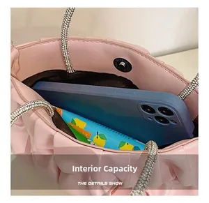 Pink pleated bag internal capacity showing storage for smartphone and small items