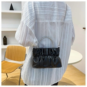 Detail of black ruched cloud bag featuring silver rhinestone handle and chain strap