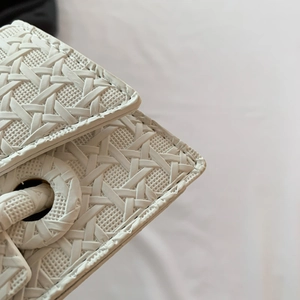 Detail of white woven texture on a minimalist handbag with elegant stitching