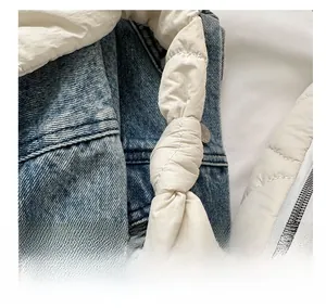 Detailed view of white quilted tote bag featuring smooth zipper and embroidery stitching