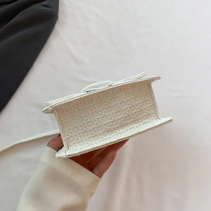 Close-up of white crossbody bag showing unique 3D woven texture and premium stitching