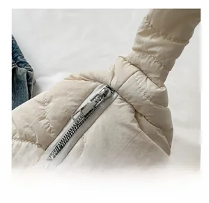 Detailed close-up of a cream quilted shoulder bag showing smooth silver metal zipper and texture