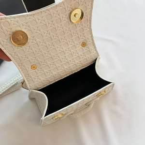 Detailed view of the woven white handbag interior with black lining and magnetic gold clasps