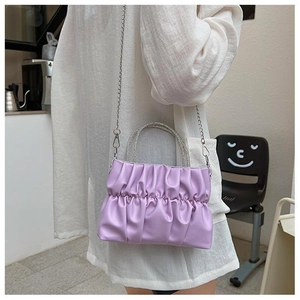 Detailed shot of lavender pleated handbag with sparkling rhinestone-encrusted handles