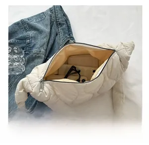 Macro view of beige quilted shoulder bag showing interior space with phone and wallet