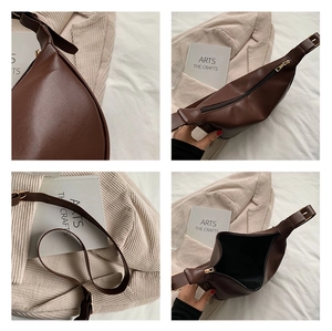 Detailed close-up of brown semi-circle crossbody bag featuring adjustable strap and gold zipper