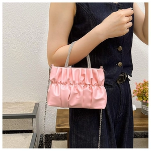 Detailed close-up of pink pleated cloud bag with shimmering diamond handles and chain strap