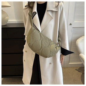 Detail of olive green quilted hobo bag featuring wavy texture and stylish knotted shoulder strap